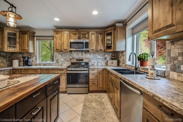 1355 Maxfield Rd, Brighton, MI 48114 - kitchen with stainless steel appliances, wooden counters, backsplash, pendant lighting, and recessed lighting