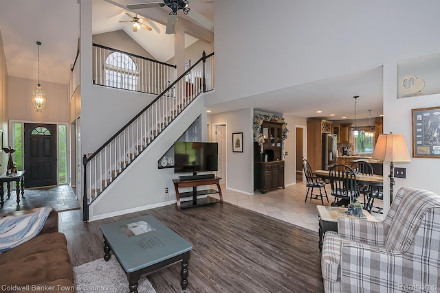 1355 Maxfield Rd, Brighton, MI 48114 - living room featuring a ceiling fan, high vaulted ceiling, plenty of natural light, stairs, and light wood-type flooring