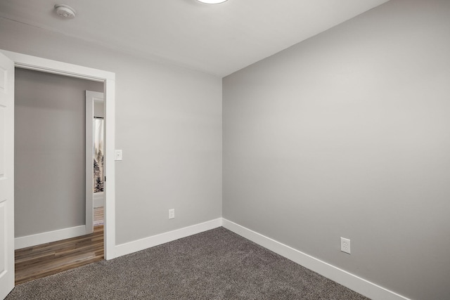 645 Amity Ave, Muskegon, MI 49442 - unfurnished bedroom featuring baseboards and dark carpet