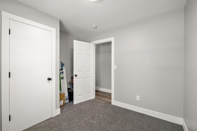645 Amity Ave, Muskegon, MI 49442 - unfurnished bedroom with dark colored carpet and baseboards