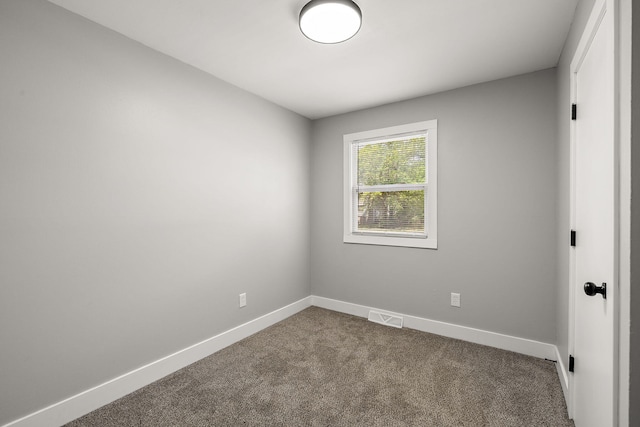 645 Amity Ave, Muskegon, MI 49442 - spare room featuring dark colored carpet and baseboards