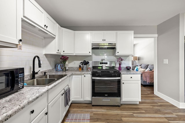 645 Amity Ave, Muskegon, MI 49442 - kitchen with stainless steel gas range oven, under cabinet range hood, black microwave, decorative backsplash, and white cabinets