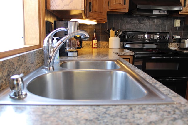 7680 S Warner Ave, Fremont, MI 49412 - kitchen featuring electric range, ventilation hood, brown cabinetry, backsplash, and light countertops