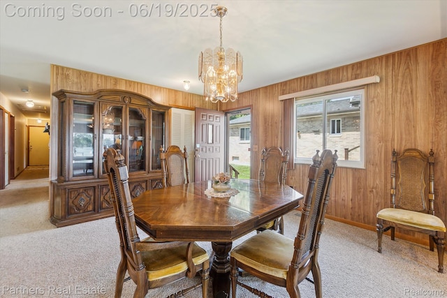 8331 Hilton Rd, Brighton, MI 48114 - dining area with a chandelier, light carpet, and wooden walls