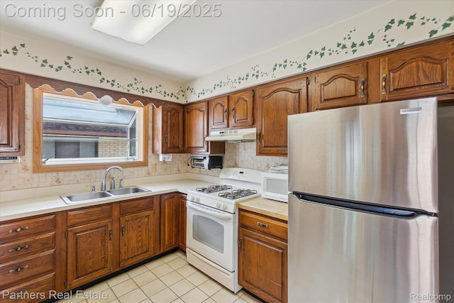 8331 Hilton Rd, Brighton, MI 48114 - kitchen with white appliances, under cabinet range hood, brown cabinets, light countertops, and light tile patterned flooring