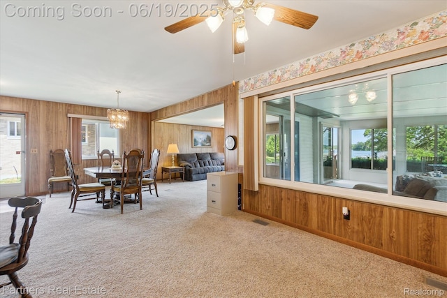 8331 Hilton Rd, Brighton, MI 48114 - dining area featuring carpet, wooden walls, a ceiling fan, and a chandelier