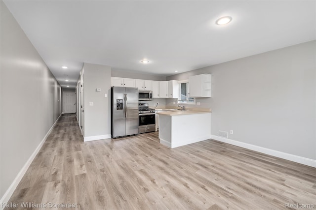 1545 W 9 Mile Rd, Ferndale, MI 48220 - kitchen with appliances with stainless steel finishes, light wood finished floors, light countertops, recessed lighting, and white cabinetry