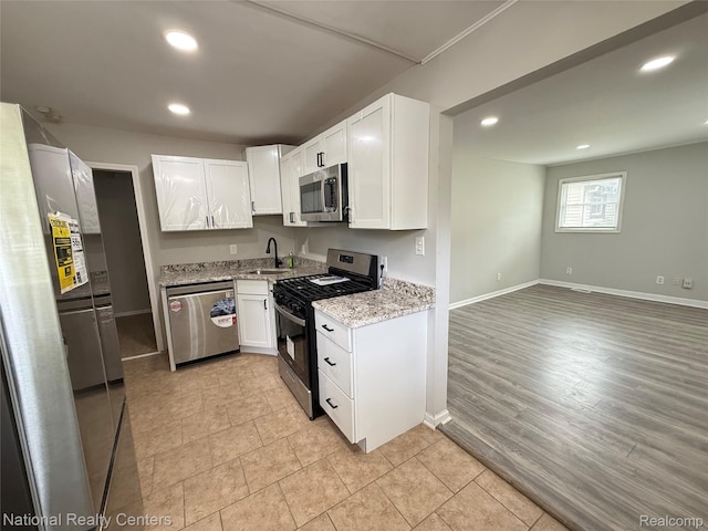 23074 Bolam Ave, Warren, MI 48089 - kitchen with stainless steel appliances, recessed lighting, light stone countertops, white cabinetry, and open floor plan
