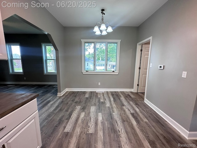 101 Morrell St, Yale, MI 48097 - unfurnished dining area featuring arched walkways, dark wood-style floors, and a chandelier