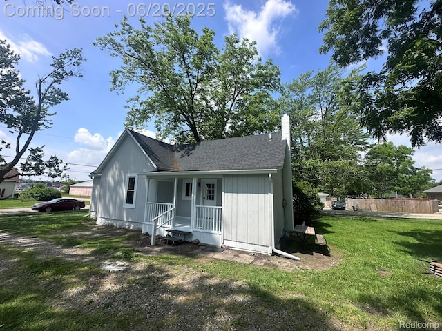 101 Morrell St, Yale, MI 48097 - rear view of house with a chimney, a lawn, and a shingled roof