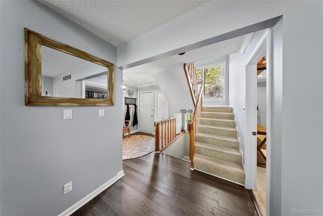 8206 Saint James Ct, Grosse Ile, MI 48138 - entrance foyer featuring a textured ceiling, dark wood-type flooring, and stairs
