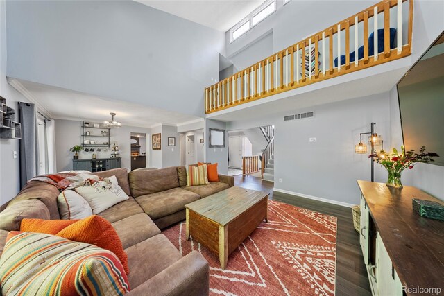 8206 Saint James Ct, Grosse Ile, MI 48138 - living area with a high ceiling, dark wood-type flooring, stairway, a chandelier, and crown molding