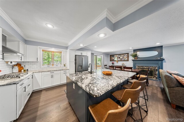 8206 Saint James Ct, Grosse Ile, MI 48138 - kitchen with appliances with stainless steel finishes, dark wood finished floors, light stone counters, ornamental molding, and recessed lighting