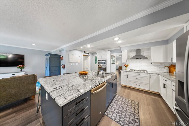 8206 Saint James Ct, Grosse Ile, MI 48138 - kitchen featuring stainless steel appliances, wall chimney range hood, ornamental molding, white cabinetry, and light stone countertops