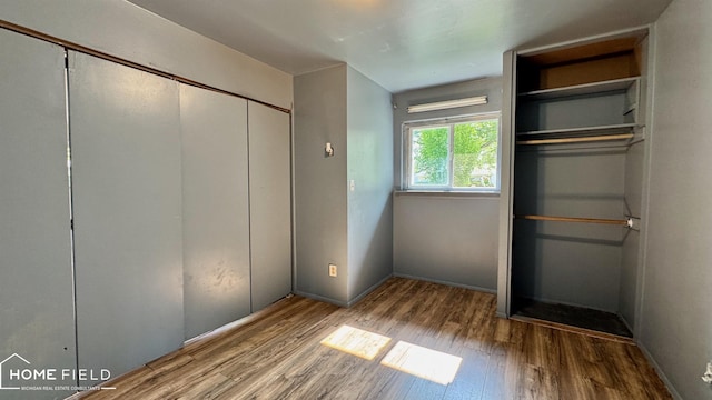 713 Wiltshire Dr, Owosso, MI 48867 - unfurnished bedroom featuring wood finished floors and baseboards