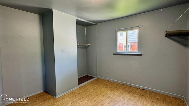 713 Wiltshire Dr, Owosso, MI 48867 - unfurnished bedroom with wood finished floors and baseboards