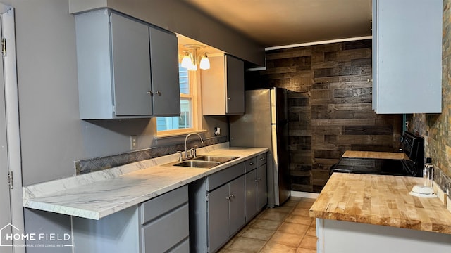 713 Wiltshire Dr, Owosso, MI 48867 - kitchen with black electric range, gray cabinetry, light tile patterned flooring, and wood counters
