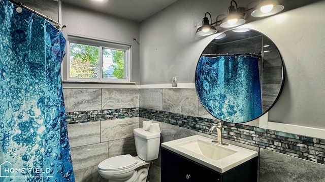713 Wiltshire Dr, Owosso, MI 48867 - full bathroom with tile walls, vanity, curtained shower, and a wainscoted wall