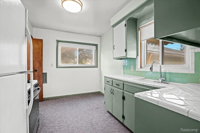 24845 Petersburg Ave, Eastpointe, MI 48021 - kitchen featuring freestanding refrigerator, tile countertops, stove, tasteful backsplash, and plenty of natural light