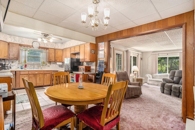 52 Roseneath Ave, Battle Creek, MI 49037 - dining area featuring a paneled ceiling, a chandelier, light colored carpet, ceiling fan, and wood walls