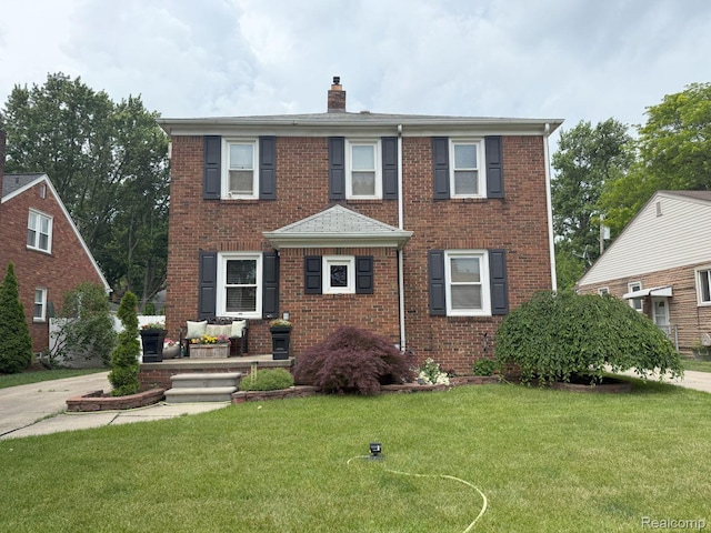 2130 Geneva St, Dearborn, MI 48124 - traditional-style home featuring a chimney, brick siding, and a front yard
