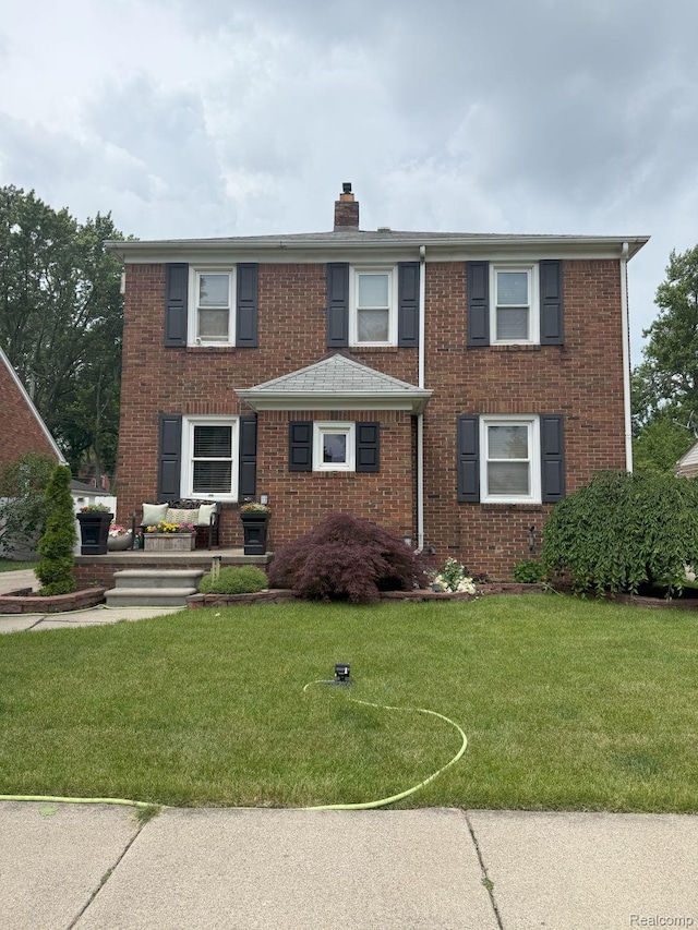 2130 Geneva St, Dearborn, MI 48124 - view of front facade featuring a chimney, brick siding, and a front lawn