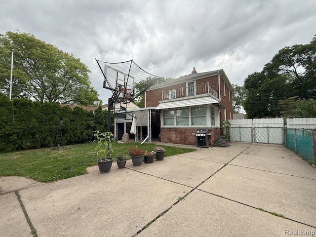 2130 Geneva St, Dearborn, MI 48124 - back of house featuring a balcony, brick siding, a chimney, a gate, and a patio