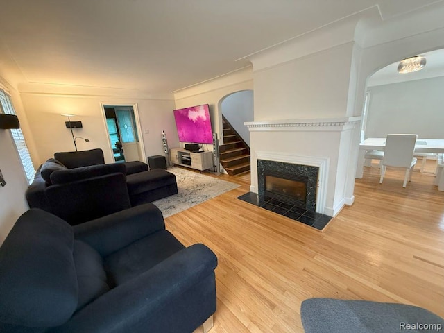 2130 Geneva St, Dearborn, MI 48124 - living room featuring wood finished floors, arched walkways, and a fireplace