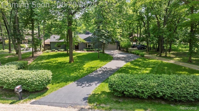 21089 Thorofare Rd, Grosse Ile, MI 48138 - view of home's community featuring a lawn, asphalt driveway, and an attached garage