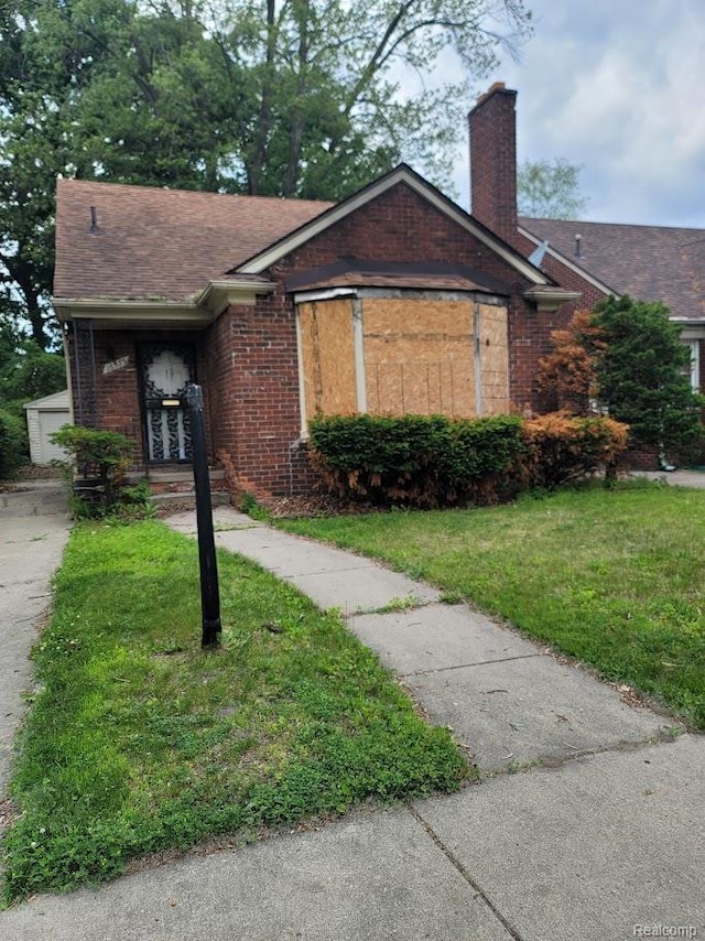 16575 Pinehurst St, Detroit, MI 48221 - single story home featuring brick siding, a front lawn, and a chimney