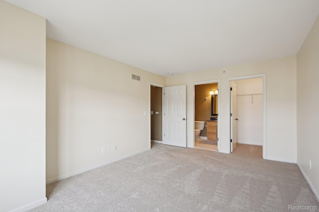 3207 Camden Dr Unit 110, Troy, MI 48084 - unfurnished bedroom featuring light colored carpet, connected bathroom, and a walk in closet
