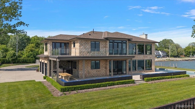 8349 Dixie Hwy, Ira, MI 48023 - rear view of house featuring a balcony, driveway, a garage, a lawn, and a patio