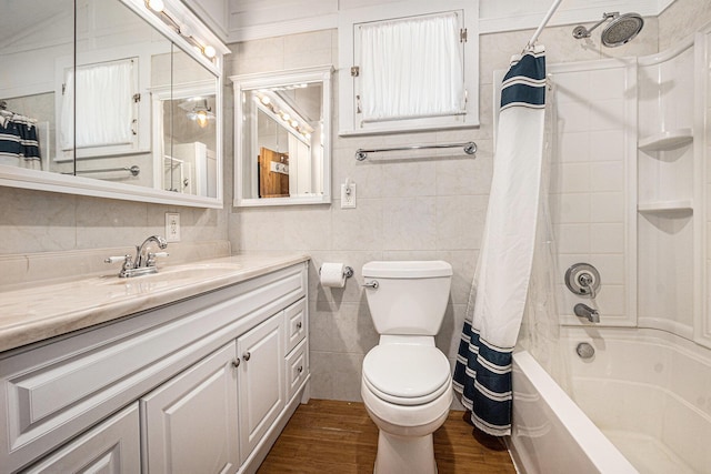 8641 N Perry Ave, Pentwater, MI 49449 - full bathroom with tile walls, vanity, shower / bathtub combination with curtain, and wood finished floors