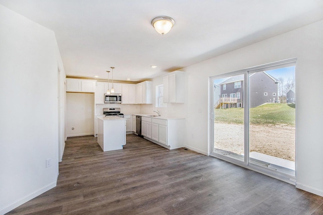 5698 Landrum Trl, Portage, MI 49024 - kitchen featuring stainless steel appliances, dark wood-style floors, white cabinets, light countertops, and hanging light fixtures