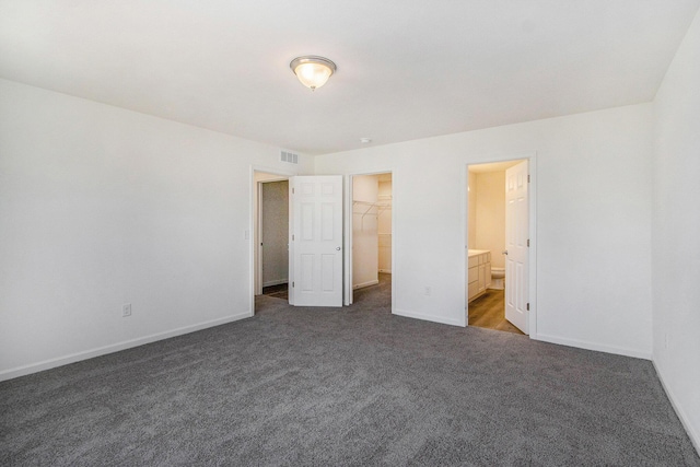 5698 Landrum Trl, Portage, MI 49024 - unfurnished bedroom featuring carpet floors, a walk in closet, ensuite bath, and a closet