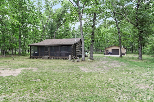 9210/9228 S Star Lake Dr, Baldwin, MI 49304 - view of grassy yard featuring a sunroom, a garage, an outdoor structure, and view of scattered trees