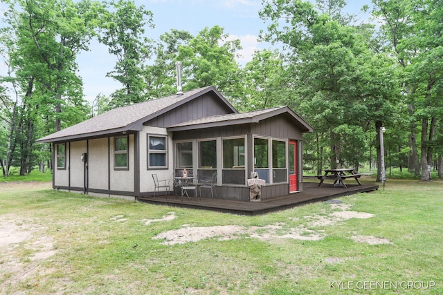 9210/9228 S Star Lake Dr, Baldwin, MI 49304 - back of property featuring a wooden deck, a shingled roof, a yard, and a sunroom
