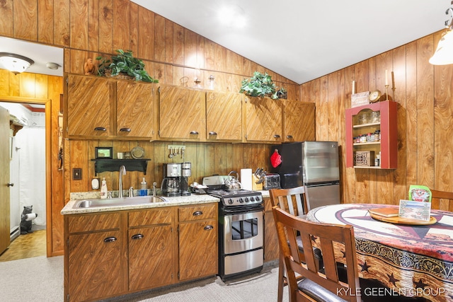 9210/9228 S Star Lake Dr, Baldwin, MI 49304 - kitchen with appliances with stainless steel finishes, wooden walls, lofted ceiling, light countertops, and light carpet