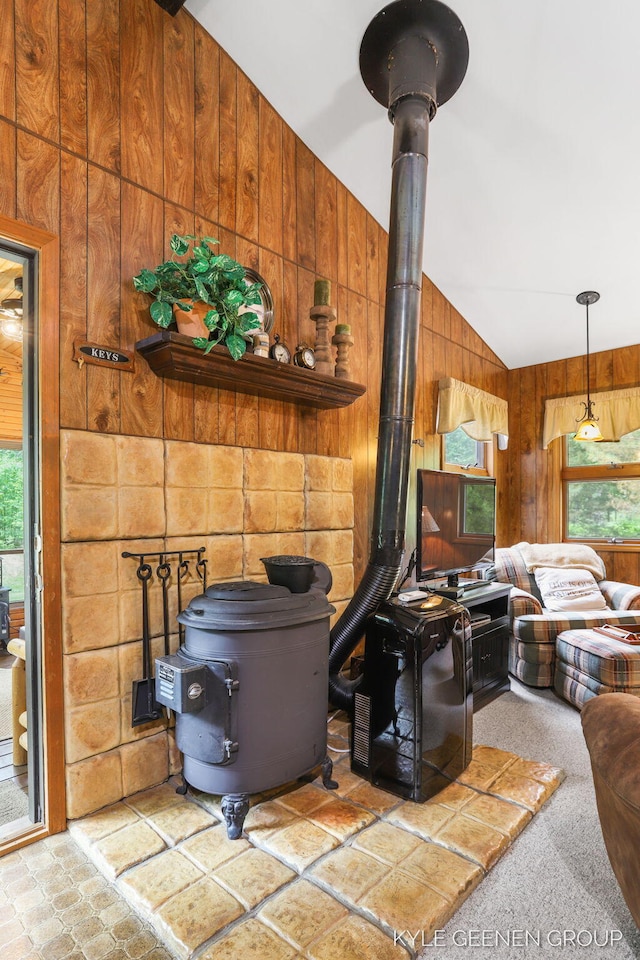9210/9228 S Star Lake Dr, Baldwin, MI 49304 - living room featuring a wood stove, wood walls, healthy amount of natural light, and lofted ceiling
