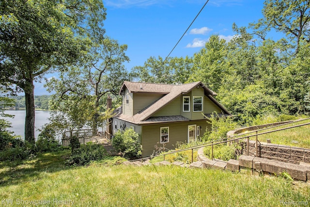 332 Community Dr, Battle Creek, MI 49014 - view of side of home featuring a water view and roof with shingles