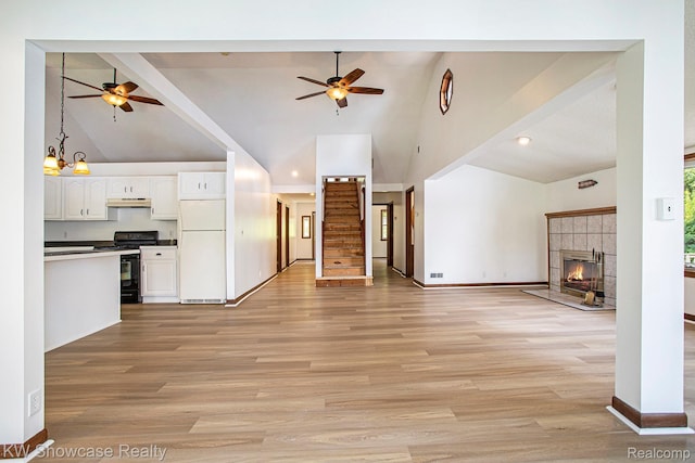 332 Community Dr, Battle Creek, MI 49014 - unfurnished living room featuring ceiling fan, high vaulted ceiling, a tiled fireplace, light wood-style flooring, and recessed lighting