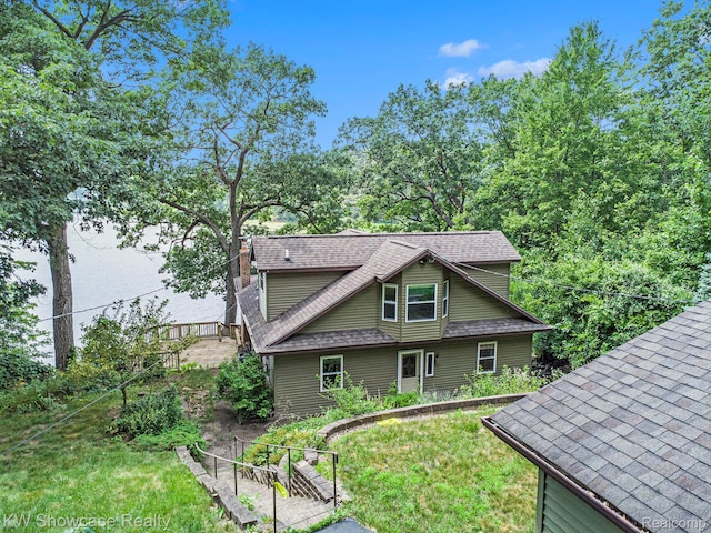 332 Community Dr, Battle Creek, MI 49014 - back of house with roof with shingles, a chimney, and a yard