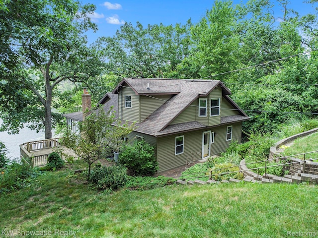 332 Community Dr, Battle Creek, MI 49014 - view of property exterior featuring roof with shingles, a yard, a chimney, and a deck