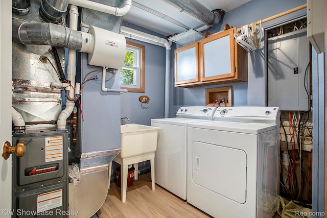 332 Community Dr, Battle Creek, MI 49014 - laundry area featuring washer and dryer, heating unit, and light wood-type flooring