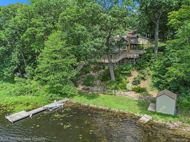 332 Community Dr, Battle Creek, MI 49014 - view of yard with stairs, a boat dock, a shed, and a deck with water view