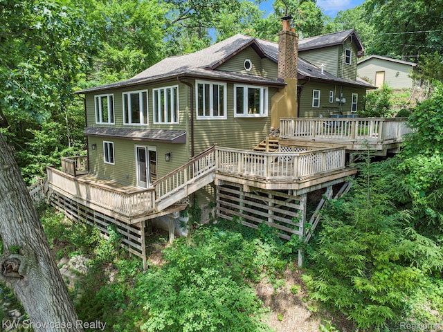 332 Community Dr, Battle Creek, MI 49014 - rear view of property with a wooden deck, stairway, a shingled roof, and a chimney
