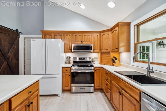 11852 Rathbun Rd, Birch Run, MI 48415 - kitchen with appliances with stainless steel finishes, light countertops, brown cabinetry, high vaulted ceiling, and a barn door
