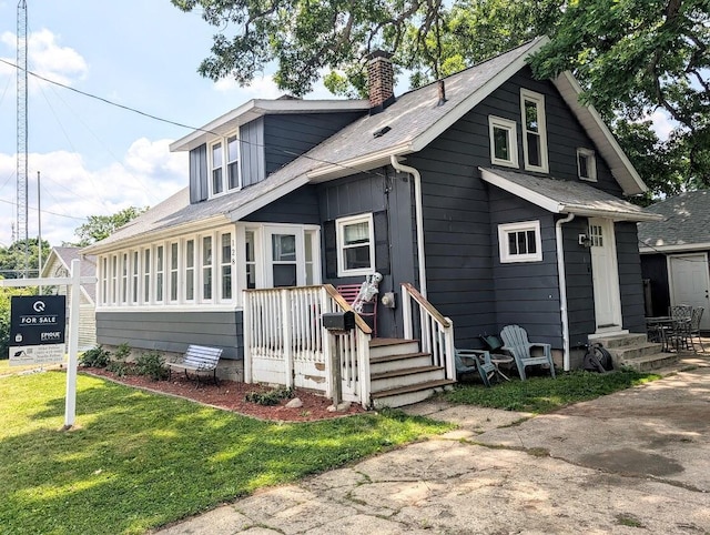 128 E Walnut St, Hastings, MI 49058 - view of front of home featuring a chimney, entry steps, a front yard, and a shingled roof