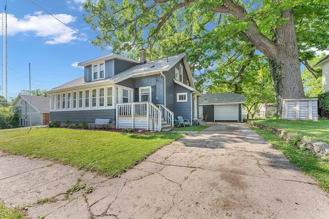 128 E Walnut St, Hastings, MI 49058 - view of front facade with driveway, a chimney, a garage, a front lawn, and an outbuilding