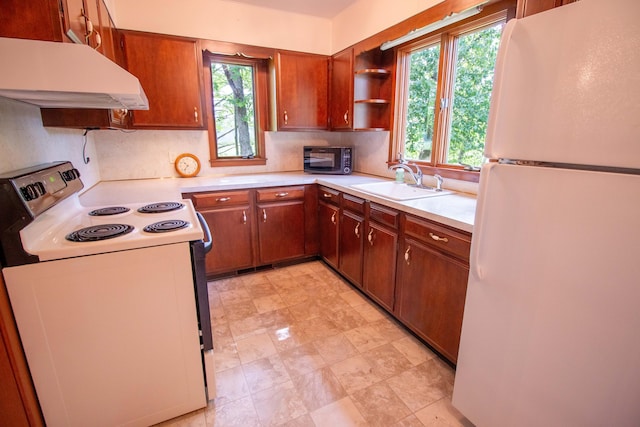 5774 N Wayne Ave, Pentwater, MI 49449 - kitchen featuring white appliances, custom exhaust hood, light countertops, decorative backsplash, and brown cabinetry